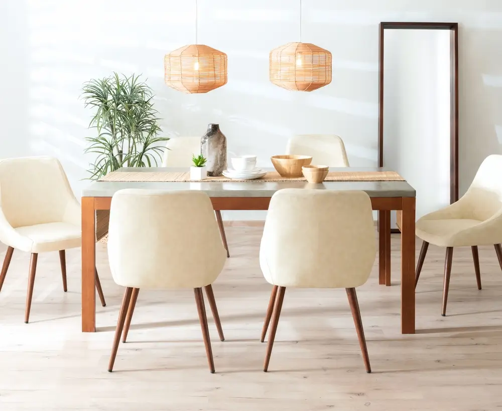 Salle à manger d'inspiration scandinave avec chaises en similicuir crème et table en bois.