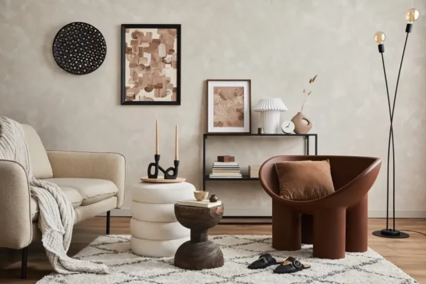 Elegant interior of living room with beige sofa, black console, brown creative armchair, modern lamp, mock up poster frame and stylish home decorations.